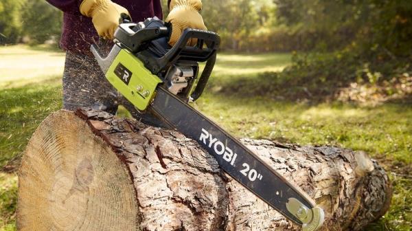 Person cutting log with chainsaw